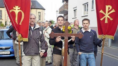 Die Poppenrother gehen am 13. September wieder auf Wallfahrt zum Kreuzberg. Ein besonderes Jubiläum begeht das Trio der Kreuz- und Fahnenträger. Seit zehn Jahren führen Sebastian Beck und Manfred Stenke und Christian Wehner die Wallfahrtsgruppe an. Foto: Lothar Metz