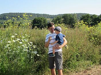 Landwirt Jochen Then zeigt schon seinem kleinen Sohn, was auf seinem angelegten Gewässerschutzstreifen alles wächst. Theresie Dietz