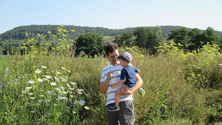 Landwirt Jochen Then zeigt schon seinem kleinen Sohn, was auf seinem angelegten Gewässerschutzstreifen alles wächst. Theresie Dietz