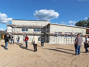 Der Gemeinderat beim Ortstermin auf dem planierten Aushub: Mit rot markierten Pfählen wurde die Grundstücksgrenze zum Kindergarten angezeigt. Hier war ursprünglich eine vier Meter tiefe Kante geplant gewesen. Foto: Adelheid Waschka