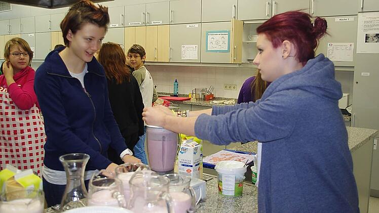 Carina Hader und Ann-Christin Reischl (vorne von links) bereiten einen Erdbeer-Milchshake zu. Fotos: Heike Schülein