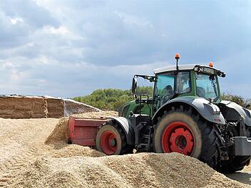 Nach dem Abladen der Mais-Häckselmasse verdichten Schlepper den Haufen zur späteren Lagerung. Foto: Sigismund von Dobschütz
