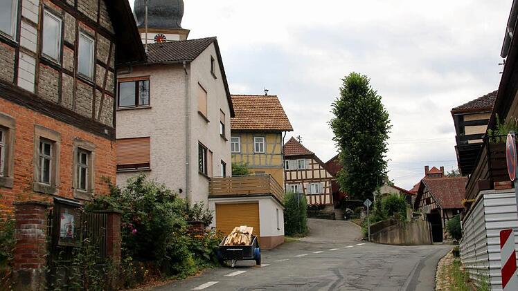 Im Zuge des Ausbaus der Bergstraße in Autenhausen lässt das Landratsamt auf Höhe der Kirche eine neue Stützmauer errichten. Für diese müssen das Kriegerdenkmal versetzt und die Linde gefällt werden, informierten die Verantwortlichen bei einer Bürgerversammlung im Sportheim. Weil ein Gehweg die Verkehrssicherheit in der Engstelle verbessern soll, wird zukünftig eine Ampel den Begegnungsverkehr dort auf ein Minimum reduzieren. Foto: Bettina Knauth