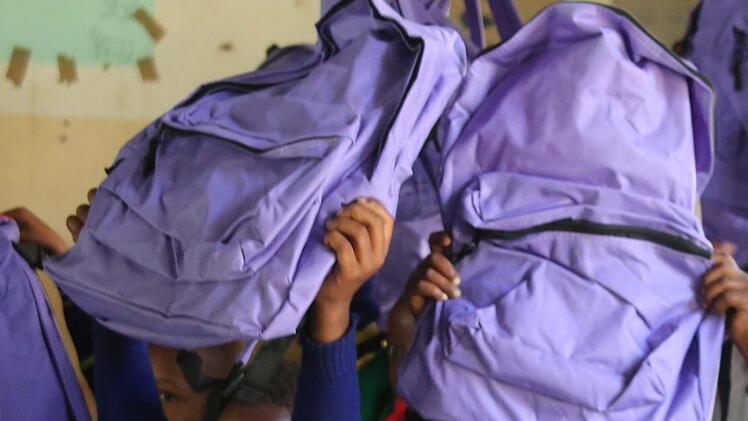 Stolz halten diese Schüler an der Kingori Primary School die Rucksäcke hoch, die sie aus der Hand der deutschen Gäste bekommen haben. Foto: Bettina Knauth