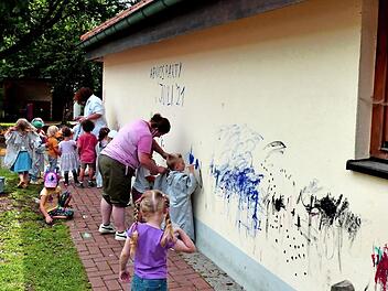Die Kinder durften mit Pinsel und Farbe die Außenfassade des Kindergartens verschönern, bevor dieser abgerissen wird.