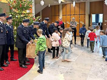 Die uniformierten Feuerwehrleute aus Oberehrenbach bringen Brezen f&uuml;r das Schulfr&uuml;hst&uuml;ck mit.