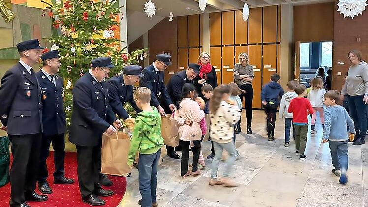 Die uniformierten Feuerwehrleute aus Oberehrenbach bringen Brezen f&uuml;r das Schulfr&uuml;hst&uuml;ck mit.