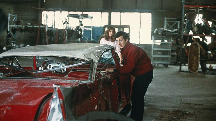 Arnie (Keith Gordon) und Leigh (Alexandra Paul) entdecken die v&ouml;llig demolierte Christine in einer Werkstadt.