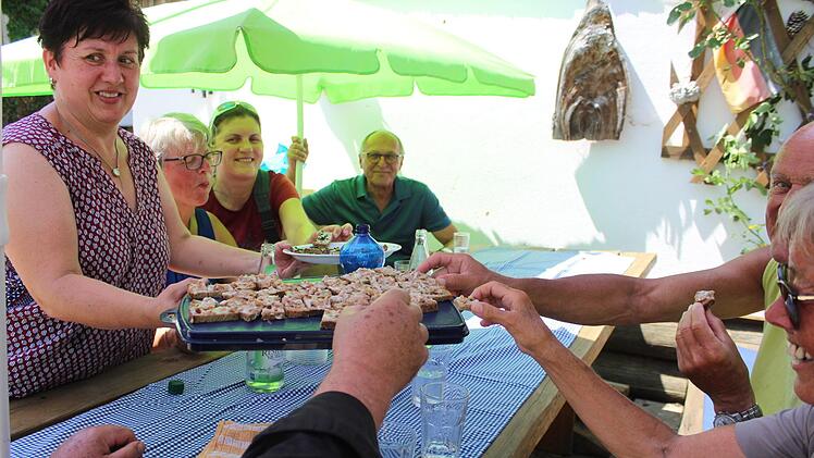 Geselliges Zugreifen - darum geht es bei den Genusswanderungen auch. Hier bietet Karin Schorn (l.) der hungrig gewanderten Gruppe Spezialitäten aus Roggen an.