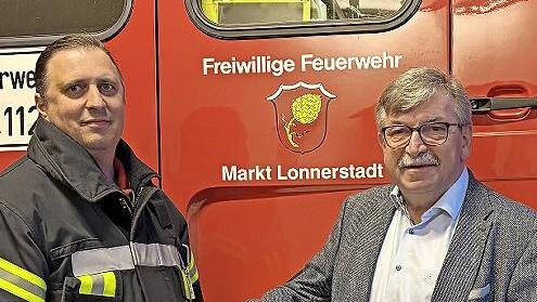 Helmut Roppelt (rechts) &uuml;bergibt Martin Kolb, Zweiter Kommandant der Freiwilligen Feuerwehr Lonnerstadt, den Schwimmsauger.