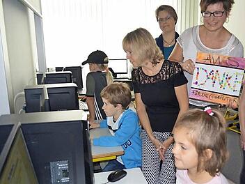 W&auml;hrend die Kinder verschiedene Programme an den neuen Computern ausprobieren, sehen ihnen Schulleiterin Rosmarie Wagner (l.) und Claudia Marie Escherich (mit Bild) &uuml;ber die Schulter. Foto: Larissa H&auml;ndel
