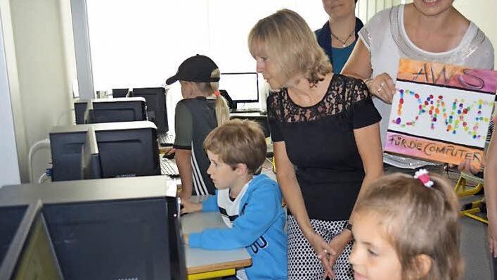 Während die Kinder verschiedene Programme an den neuen Computern ausprobieren, sehen ihnen Schulleiterin Rosmarie Wagner (l.) und Claudia Marie Escherich (mit Bild) über die Schulter. Foto: Larissa Händel