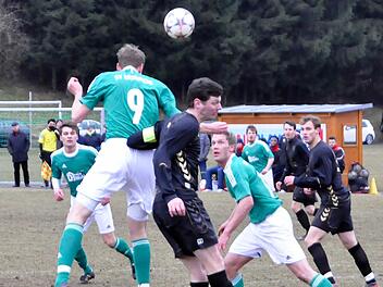 Kopfball zum Nebenmann: Philipp Dorn (Nummer 9/SV Riedenberg) lässt sich auch von einem Rempler des Wiesentheider Spielführers Christian Enzbrenner nicht am Pass auf James Galloway (rechts, dahinter) hindern. Foto: Schmitt