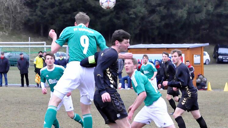 Kopfball zum Nebenmann: Philipp Dorn (Nummer 9/SV Riedenberg) lässt sich auch von einem Rempler des Wiesentheider Spielführers Christian Enzbrenner nicht am Pass auf James Galloway (rechts, dahinter) hindern. Foto: Schmitt