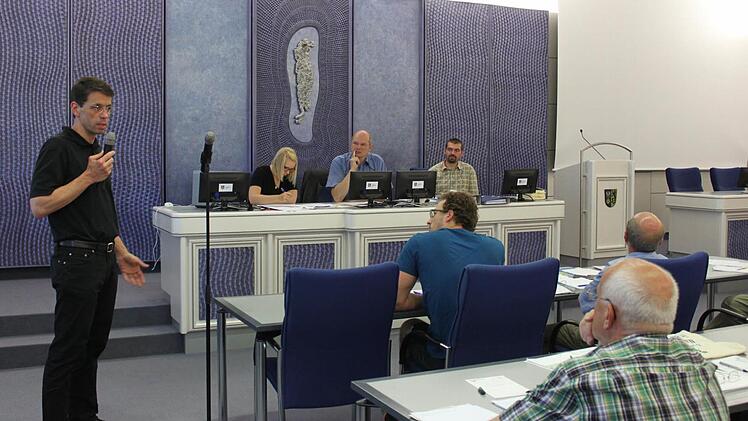 Norbert Böhm, Geschäftsführer der Bamberger Wertschmied-Group, die das Ökostromwerk am Michelauer Mainwehr plant, stellte beim Erörterungstermin im großen Saal des Landratsamtes Lichtenfels das Projekt vor und musste sich auch mit kritischen Fragen auseinandersetzen. Hinten rechts Abteilungsleiter Anton Fleischmann. Foto: Popp