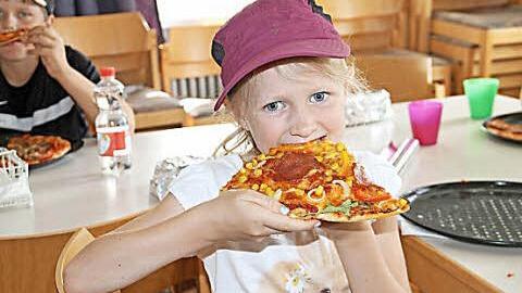 Franziska l&auml;sst sich ihre selbst belegte Pizza schmecken. Foto: Gerda V&ouml;lk