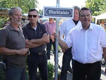 Bürgermeister Jürgen Wittmann hatte ein Schild mit der Aufschrift "Marktplatz" dabei. Es soll während des Markttreibens am Marktcafé angebracht werden . Fotos: Michael Stelzner