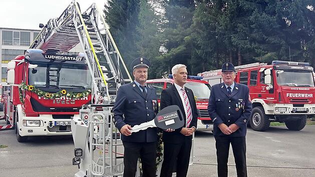 Eingeweiht und offiziell in Dienst gestellt: B&uuml;rgermeister Timo Ehrhardt (Mitte) &uuml;bergab den symbolischen Schl&uuml;ssel f&uuml;r das neue Drehleiterfahrzeug an KommandantJ&ouml;rg S&ouml;llner (links) und den Ehrenvorsitzenden Gerhard Bergmann.