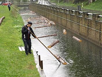 Bei der Blöchertrift müssen Holzstämme mit Stangen durch den Kanal gelotst werden. Foto: Susanne Deuerling