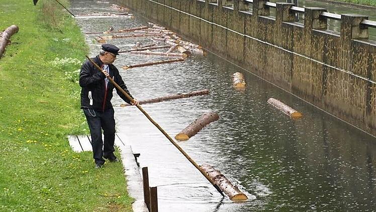 Bei der Blöchertrift müssen Holzstämme mit Stangen durch den Kanal gelotst werden. Foto: Susanne Deuerling