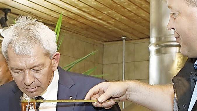 Geruchsprobe gefällig: Roland Kundmüller lässt den Landrat am frischen Sud schnuppern.