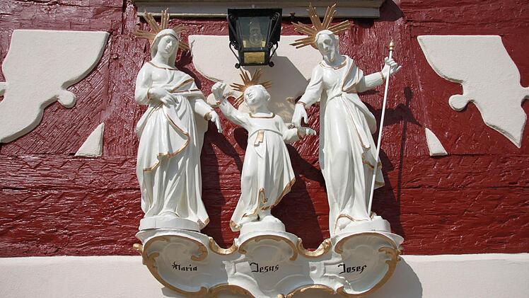 Figurengruppe in der Haßfurter Hauptstraße 62 der Familie Peter und Diana Giessegi. Harmonisch und persönlich miteinander verbunden sind Maria und Josef mit dem Jesuskind unterwegs. Diese Darstellung galt als Vorbild für den Lebenswandel einer christlichen Familie. Foto: Albin Schorn