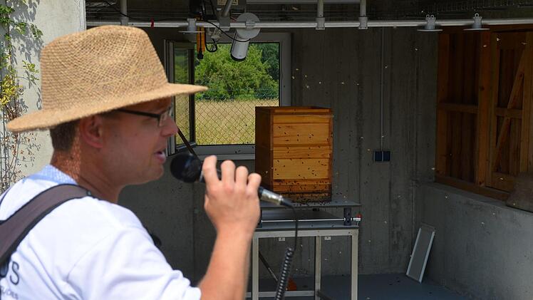 Hartmut Vierle vor dem High-Tech-Bienenstock. Links oben die Industriekamera die jeden Ein- und Ausflug sekundengenau dokumentiert. Jede Biene im Stock trägt ihr individuelles "Nummerschild" auf dem Rücken zwischen den Flügeln. Foto: Peter Rauch