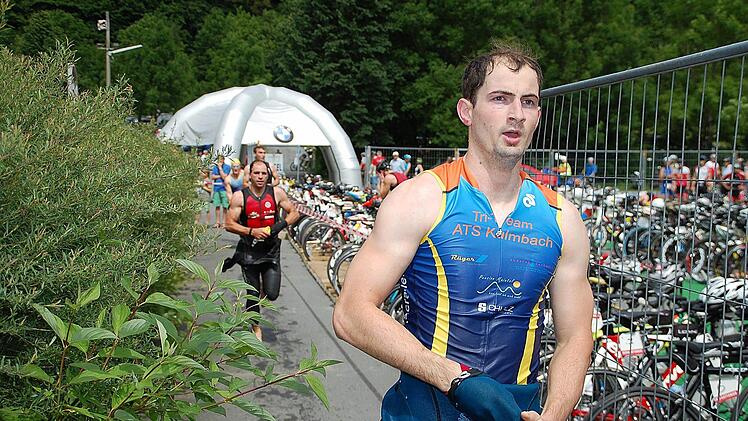 Im Laufen zieht Benedikt Weber den Neoprenanzug aus.