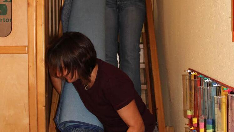 Daniela Koch (oben) und Carmen Binsteiner räumen Teppiche und Kisten wieder an Ort und Stelle.