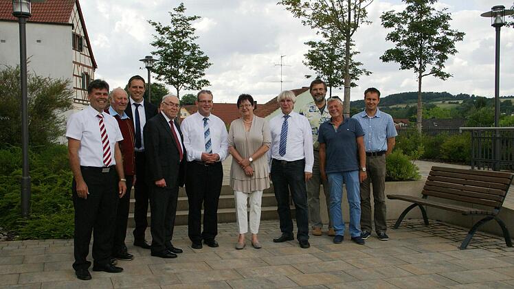 Freuten sich über eine gelungene Dorferneuerung in Trossenfurt (hier auf dem neugestalteten Kirchenvorplatz, von links): Oberaurachs Bürgermeister Thomas Sechser, der örtlich Beauftragte der Flurbereinigung Heinz Moser, Nachbarbürgermeister Matthias Bäuerlein aus Rauhenebrach, Altbürgermeister Siegmund Kerker, Pfarrer Thomas Klemm, Planerin Erika Stubenrauch, Manfred Rott und Norbert Dietmeyer vom Staatlichen Bauamt, der ehehamlige Bauamtsleiter Oberaurachs, Manfred Finster, und Manfred Stadl...
