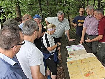 Vor dem Waldgang gab es durch die beiden Forstbeamten Wolfgang Gnannt und Jürgen Hahn (von rechts) anhand von Kartenmaterial Informationen über das Waldgebiet Wüstenhof. Bürgermeister Jürgen Hennemann (hinten Mitte) ist aufmerksam bei der Sache. Foto: Helmut Will