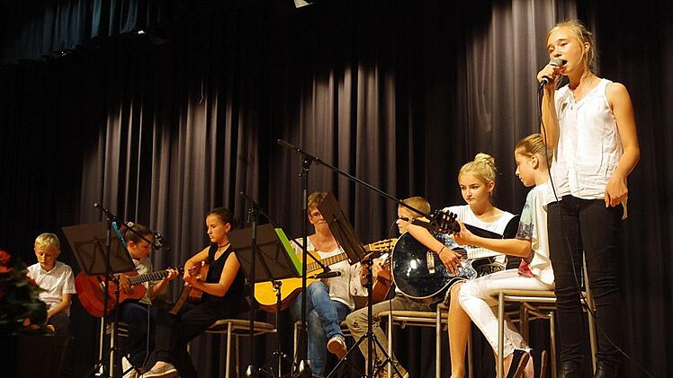 Erst zu Beginn des Schuljahres hatte sich das Gitarren-Ensemble zusammengefunden. Gesangliche Verstärkung erhielt dieses von Lara Tönnesmann, die mit "Halleluja" und "No roots" bezauberte. Foto: Heike Schülein