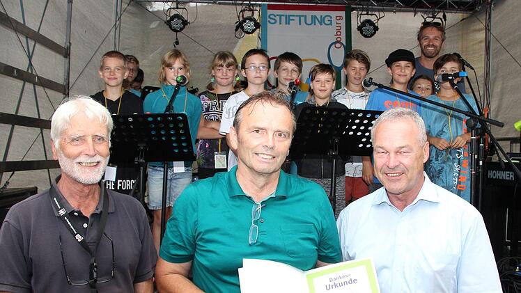 Der Vorsitzende der Stiftung Uwe Rendigs (links) und Neustadts OB Frank Rebhan - zugleich Mitglied im Stiftungsvorstand (rechts) - überreichen dem Schulleiter der Neustadter Glockenbergschule, Manfred Bergmann, eine Dankesurkunde; dahinter die 4. Klasse der Glockenbergschule mit (hinten rechts) dem Hauptorganisator des Benefizkonzerts Michael Balling. Foto: Rainer Glissnik