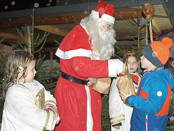 Der Nikolaus beschert mit seinen beiden Engeln Helene (links) und Nora die Kinder. Foto: Susanne Deuerling