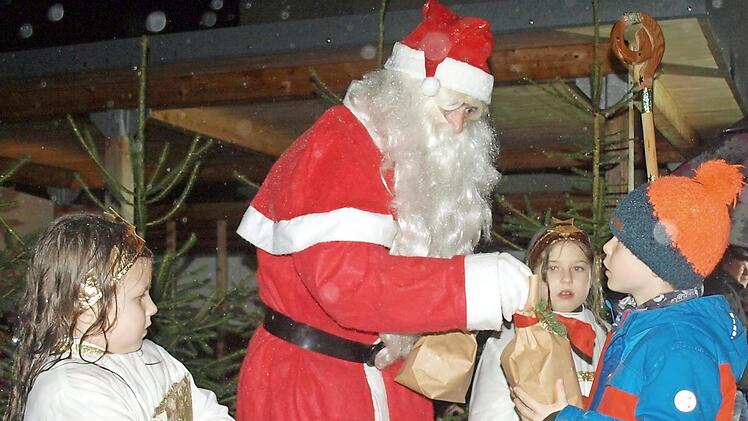Der Nikolaus beschert mit seinen beiden Engeln Helene (links) und Nora die Kinder. Foto: Susanne Deuerling