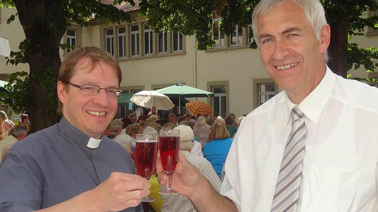 Pfarrer Dr. Manfred Bauer und Dekan Hanspeter Kern und stoßen mit einem Glas Sekt auf die gelungene Premiere des ersten Ökumenischen Gemeindefestes an. Eine Wiederauflage ist schon vorprogrammiert.