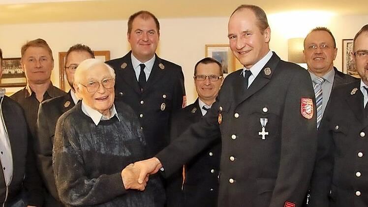 Die Feuerwehr ehrte bei ihrer Hauptversammlung viele langjährige und aktive Mitglieder. Karl Rädlein erhielt vom Vorsitzenden Elmar Schramm (Achter von links) eine besondere Ehrung.  Fotos: Michael Stelzner