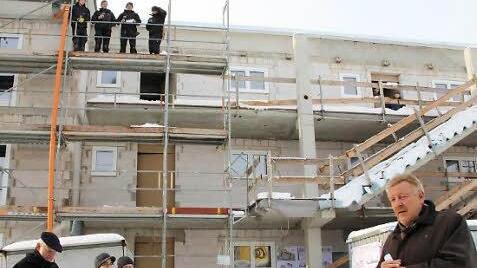 Den Richtspruch brachten die Dachdecker aus, Oberbürgermeister Norbert Kastner (rechts) erläuterte, warum die Wohnbau in Wüstenahorn neue Wohnungen baut. Foto: Simone Bastian