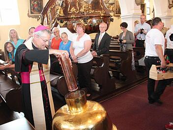 Erzbischof Ludwig Schick steckt die Bulle in die Turmkugel. Fotos: Johanna Blum