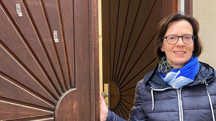 Pfarrerin Jacqueline Barraud-Volk an der Tür des Pfarrhauses - ebenfalls mit Sonnensymbol. Foto: Angelika Despang