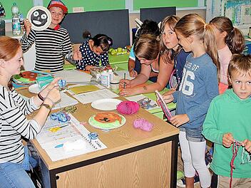 Jana Müller erklärt den Kindern, wie man aus Papptellern Masken bastelt.  Foto: Dieter Britz