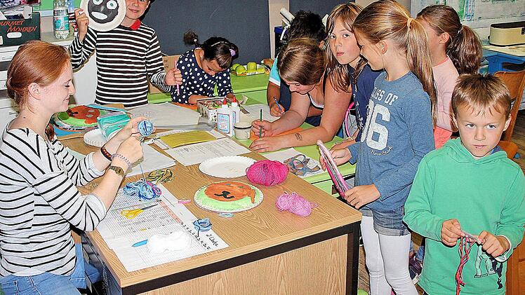 Jana Müller erklärt den Kindern, wie man aus Papptellern Masken bastelt.  Foto: Dieter Britz