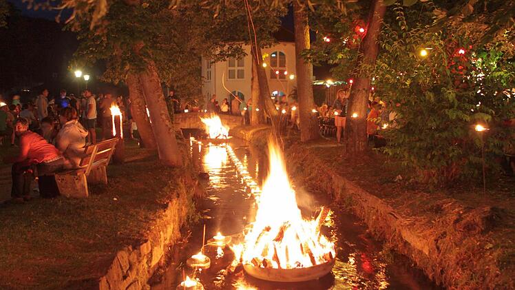 Mit Kerzenschiffchen wird der Mühlbach in "Flammen" gesetzt. Foto: Thomas Dill