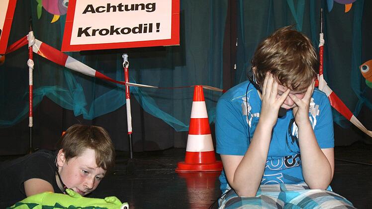 Während Jimmy (Elias Bartl, rechts) verzweifelt ist, scheint der Trubel den kleinen Kaiman Sammy (gespielt von Nick Naumann) nicht zu stören. Hauptsache es gibt was zu fressen.
