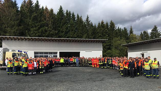 Imposantes Gruppenbild der Helferinnen und Helfer mit  Einsatzleiter Matthias Strott, Frank Reith, Leiter des Fachdienstes Gefahrenabwehr, Kreisbrandinspektor Adrian Vogler, Landrat Bernd Woide und 1. Kreisbeigeordneten Frederik Schmitt.  Foto: Leoni Rehnert