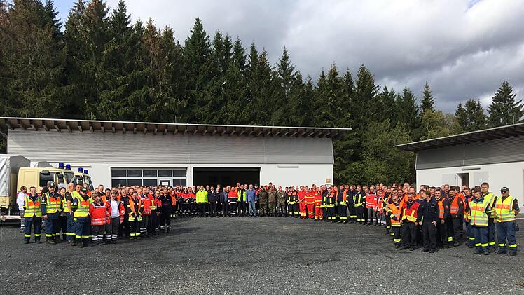 Imposantes Gruppenbild der Helferinnen und Helfer mit  Einsatzleiter Matthias Strott, Frank Reith, Leiter des Fachdienstes Gefahrenabwehr, Kreisbrandinspektor Adrian Vogler, Landrat Bernd Woide und 1. Kreisbeigeordneten Frederik Schmitt.  Foto: Leoni Rehnert