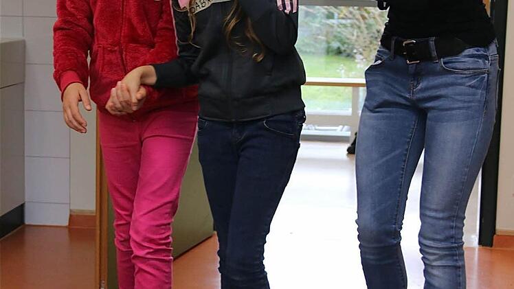 Sorgsam wacht Sarah darüber, dass Selina nicht umkippt, wenn diese blind und mit bloßen Füßen über den Parcours läuft.