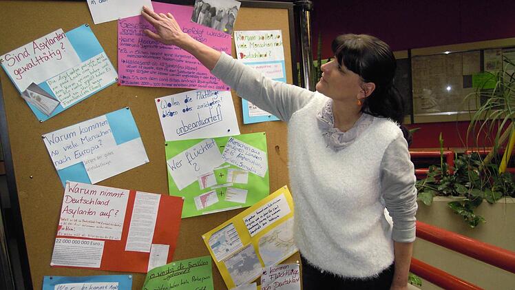 Schulleiterin Birgit Herré zeigt die Arbeit einer 8. Klasse zum Thema Flucht und Asyl. Foto: Julia Raab