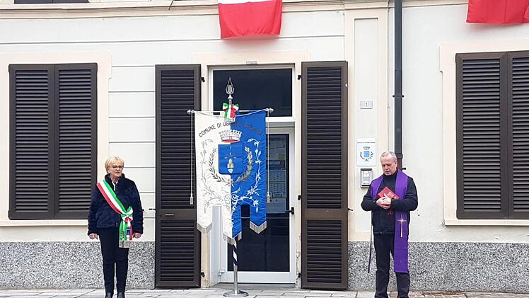 Rita Lambrughi und Don Sandro Vanoli am Dienstag bei einer Schweigeminute in Uggiate Trevano zum Gedenken an die italienischen Corona-Opfer     Foto: privat