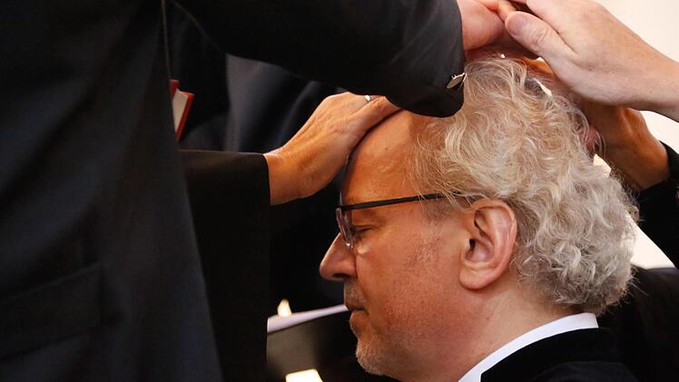 Die Bischöfin und fünf Assisten legten Hans-Martin Lechner zum Segensgebet die Hand auf. Foto: Matthias Hoch